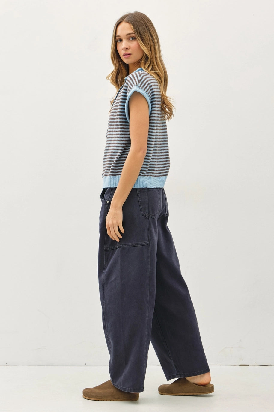 Woman wearing a striped shirt and wide-leg pants on a white background