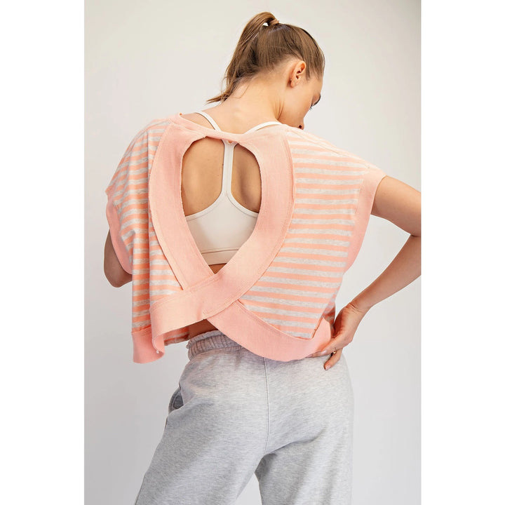Woman wearing a pink and white striped top with a plain background