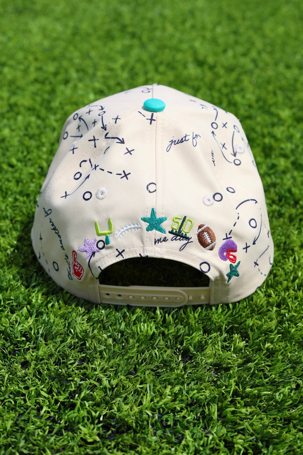 Back of trucker hat with football embroidery sitting on grass
