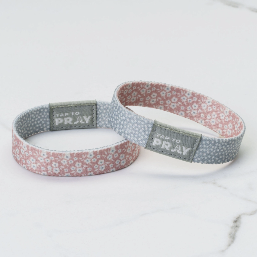 Two floral-patterned wristbands with 'Tap to Pray' labels on a white background