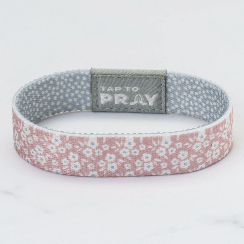 Bracelet with floral pattern and 'Tap to Pray' text on a white background