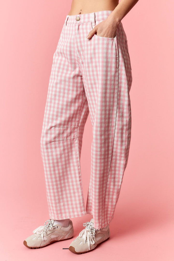 Person wearing pink and white checkered pants on a pink background