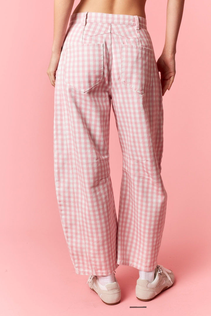 Person wearing pink checkered pants on a pink background