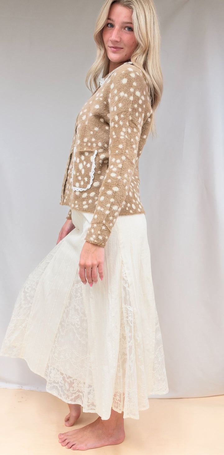 Woman shown from side view wearing fawn print jacket with lace detail maxi skirt on plain background