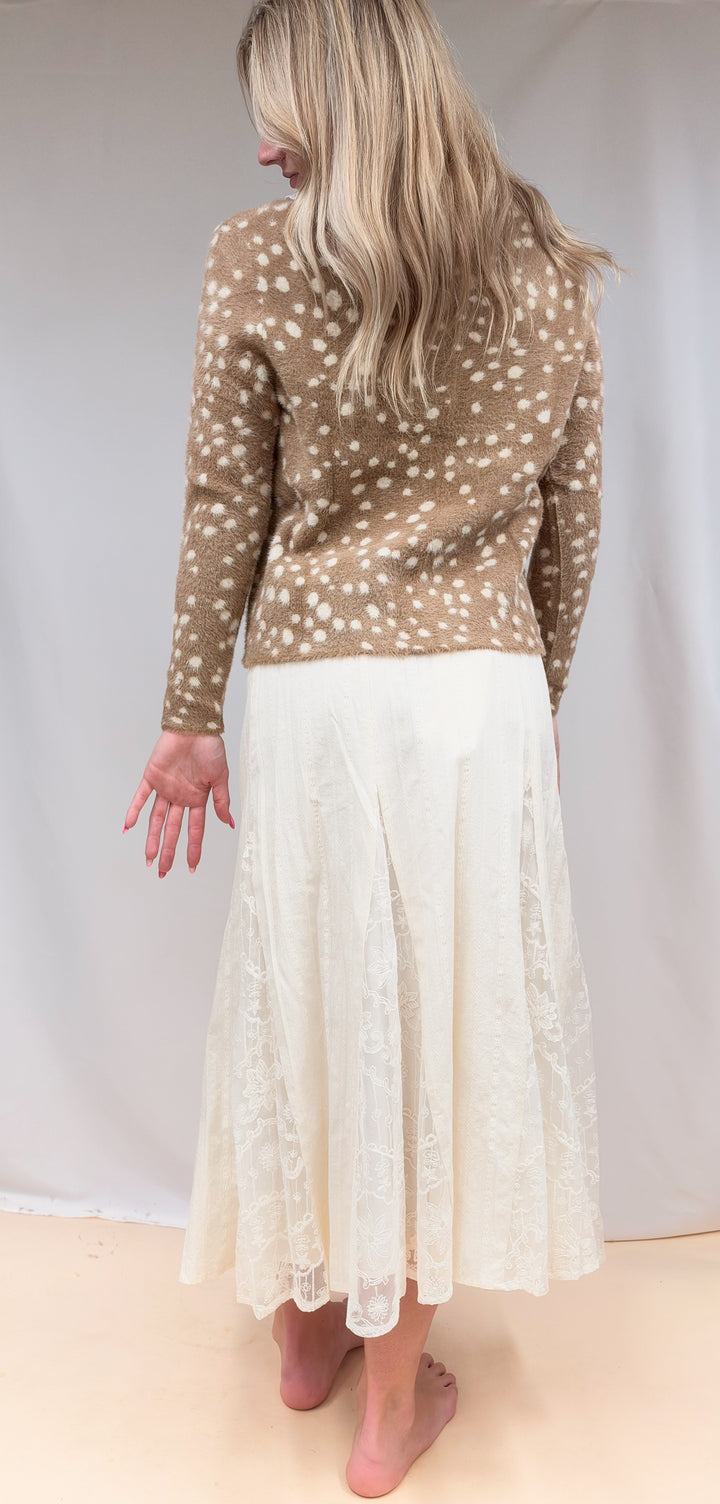 Woman shown from back view wearing fawn print jacket with lace detail maxi skirt on plain background