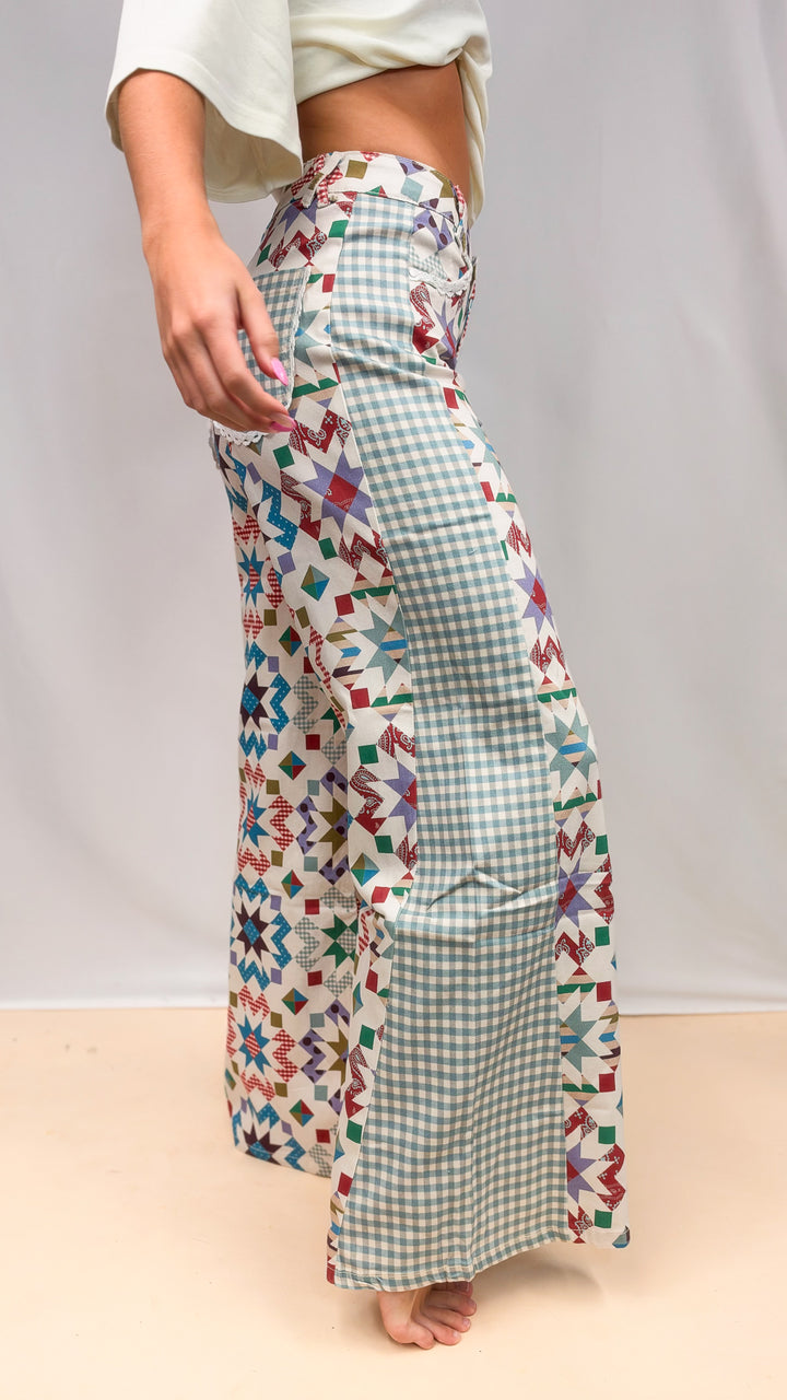 Side view of woman wearing quilted pattern pants with gingham detail on plain background