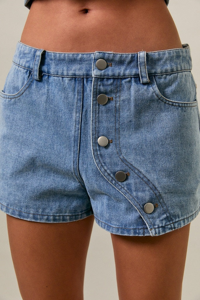 Blue denim shorts with button details on a neutral background