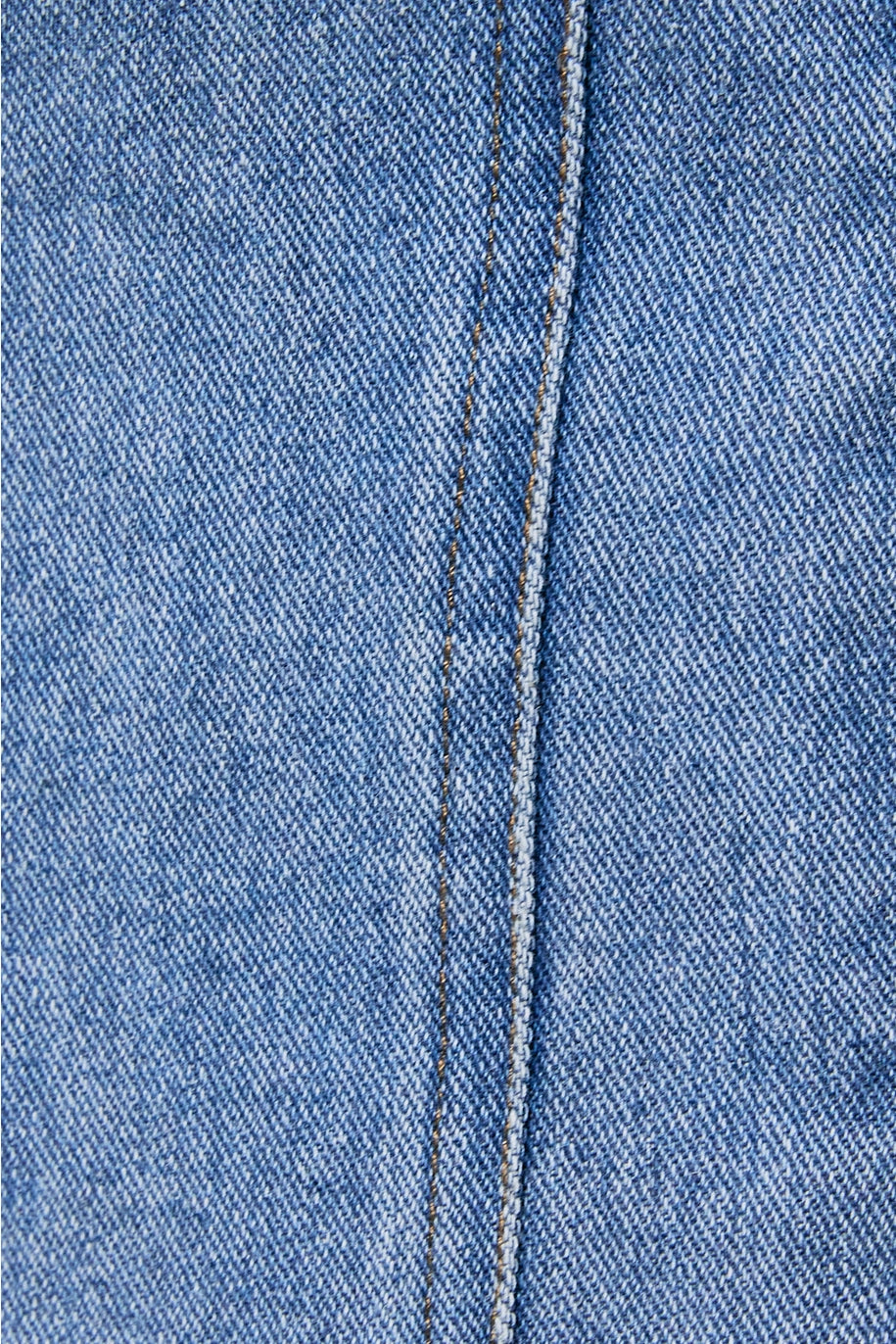 Close-up of blue denim fabric with a visible seam.