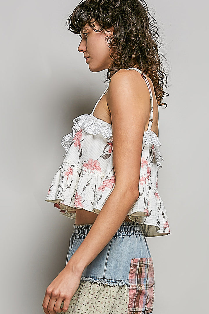 Woman wearing a floral top and patchwork skirt against a plain background
