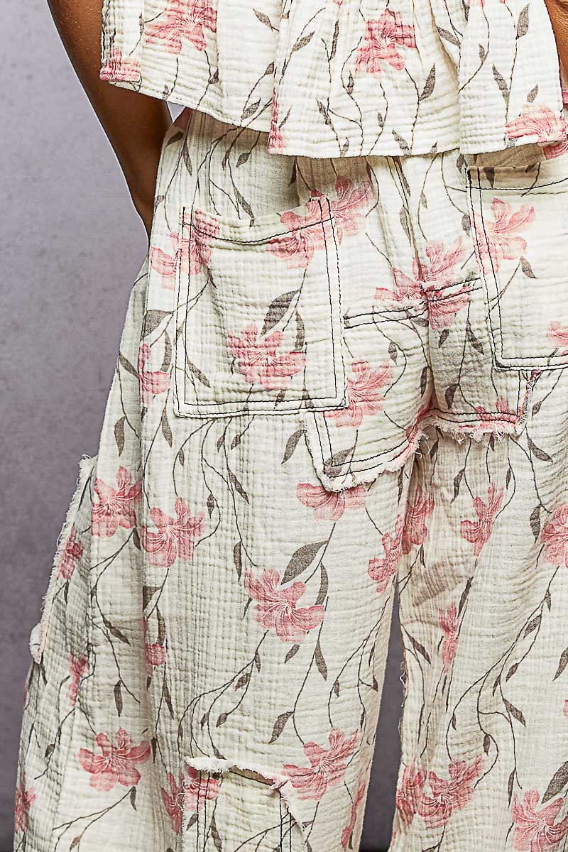 Floral patterned outfit with a focus on pants against a neutral background