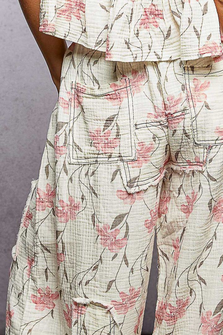 Floral patterned outfit with a focus on pants against a neutral background