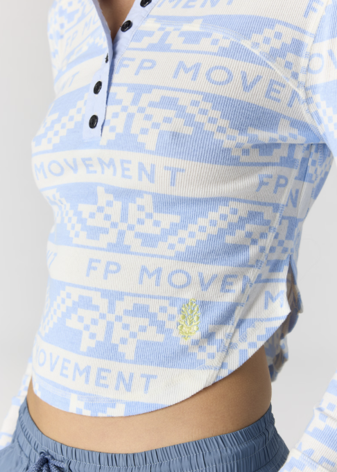 Close up of woman wearing blue and white printed henley on white background