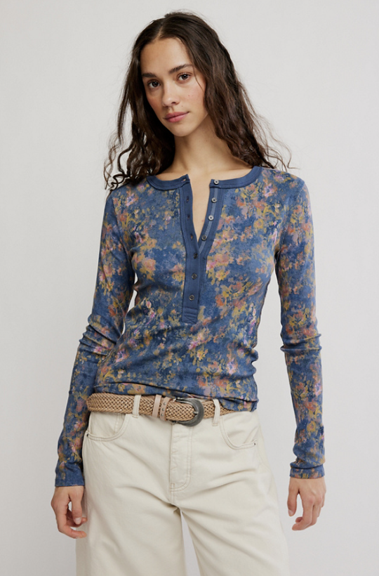 Woman wearing floral printed henley shirt on white background