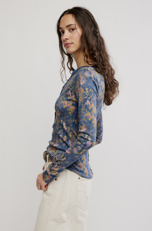 Woman wearing a blue floral long-sleeve top against a white background