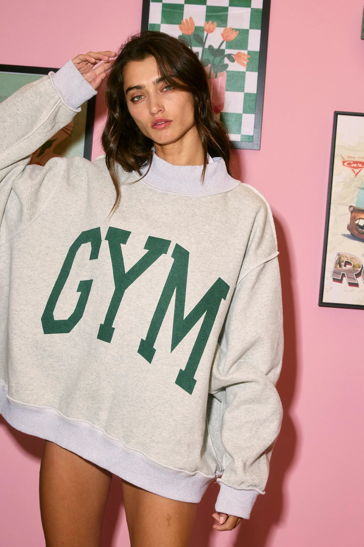 Woman wearing a gray sweatshirt with &