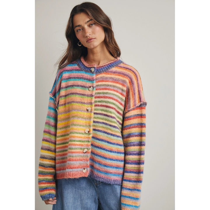 Woman wearing rainbow stripe cardigan against plain background