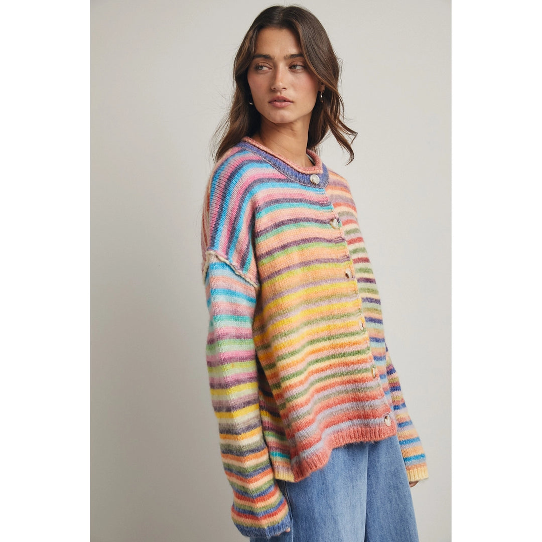 Woman wearing rainbow stripe cardigan on plain background