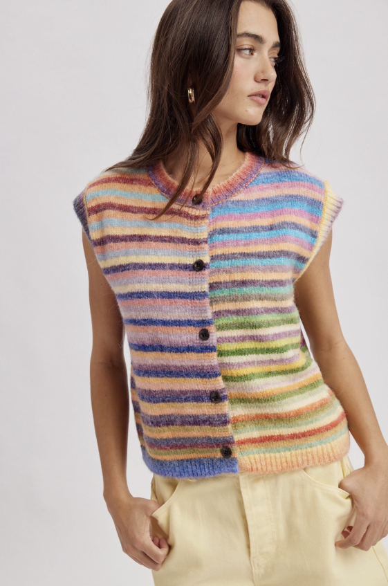 Woman wearing stripe colorful button up vest on plain background