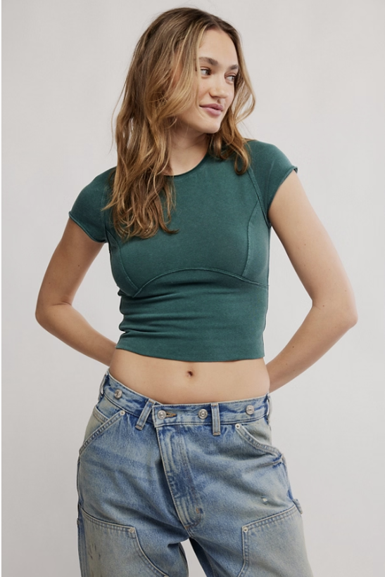 Woman wearing green tee and blue jeans on white background