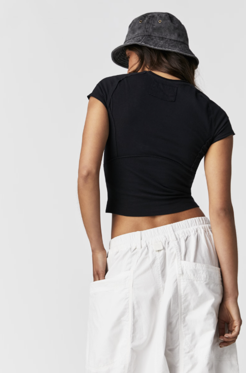 Woman wearing black tee and white pants on white background