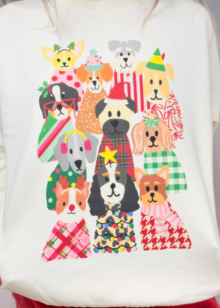 Close up of cream sweatshirt with multiple dogs in Christmas decor 