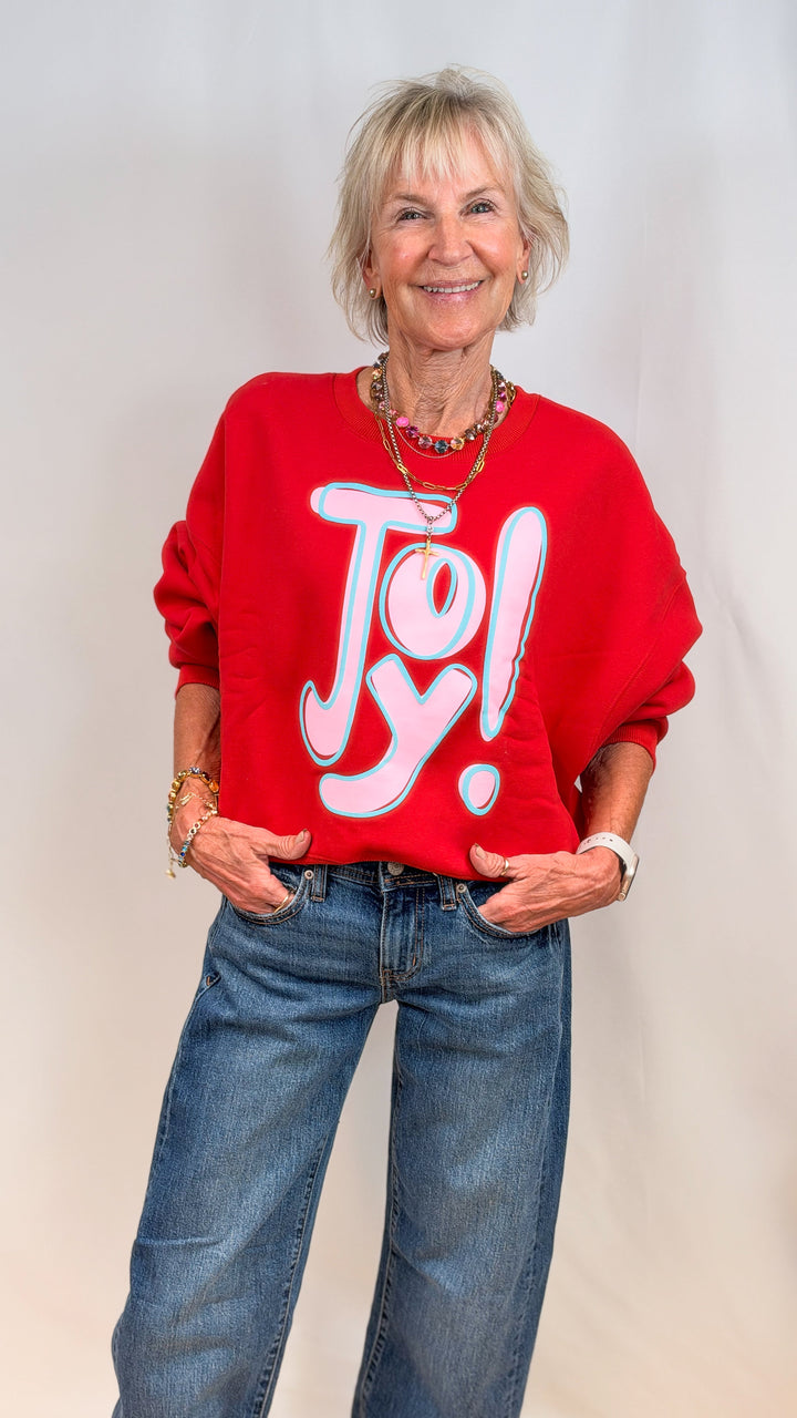 Woman wearing red sweatshirt with &
