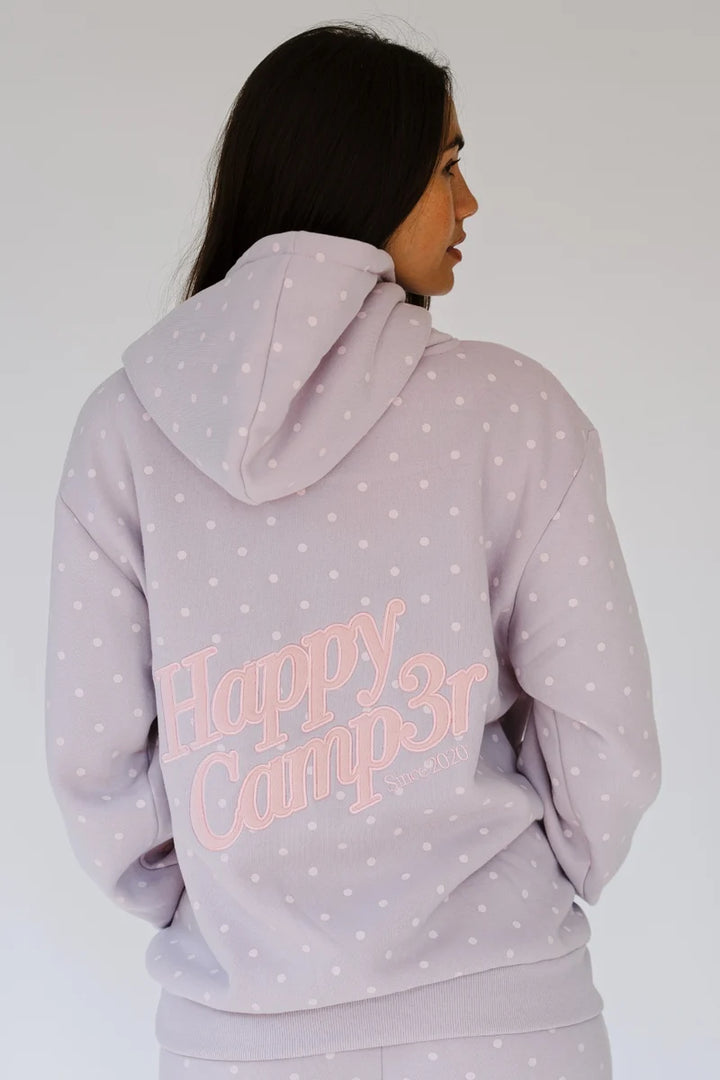 A woman shown from the back wearing a light lavender hoodie with white polka dots and a pink &