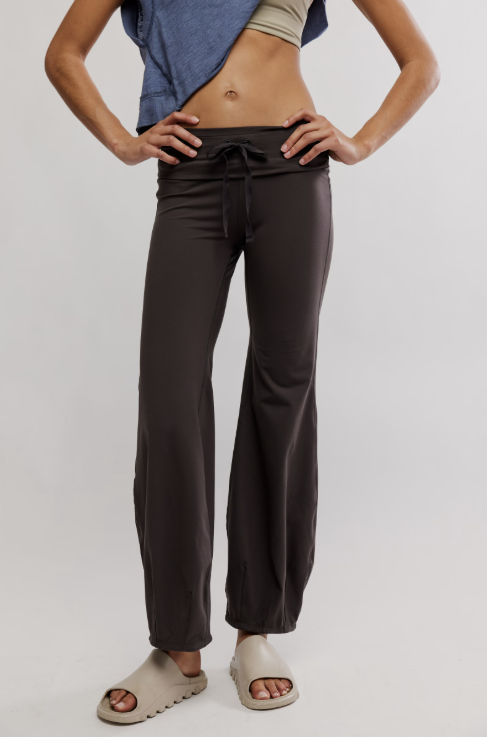Person wearing dark gray pants on a plain background