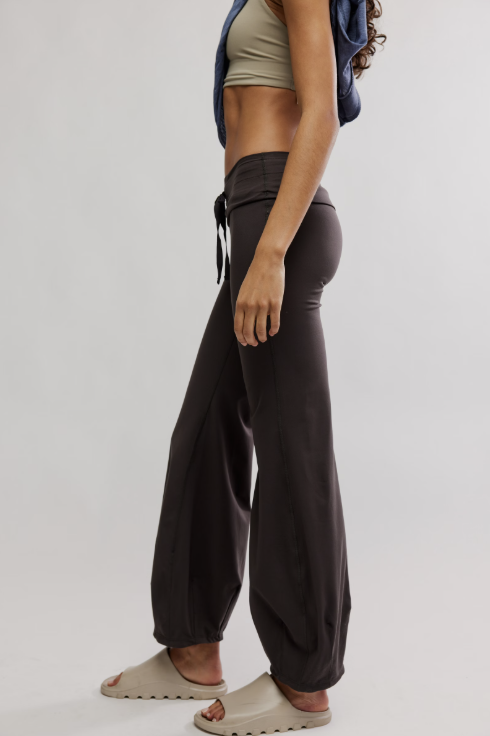 Person wearing dark brown wide-leg pants on a plain background