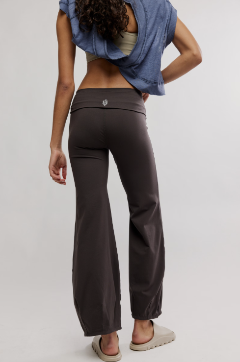 Person wearing dark brown pants with a plain background