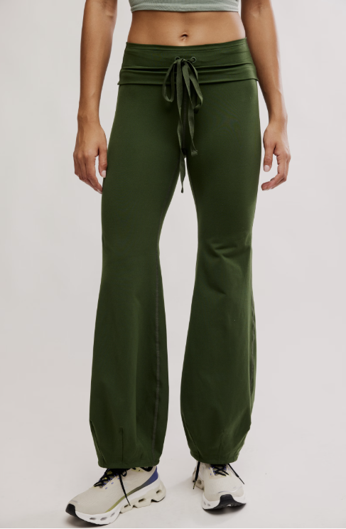 Person wearing green wide-leg pants with a tie-waist design on a white background
