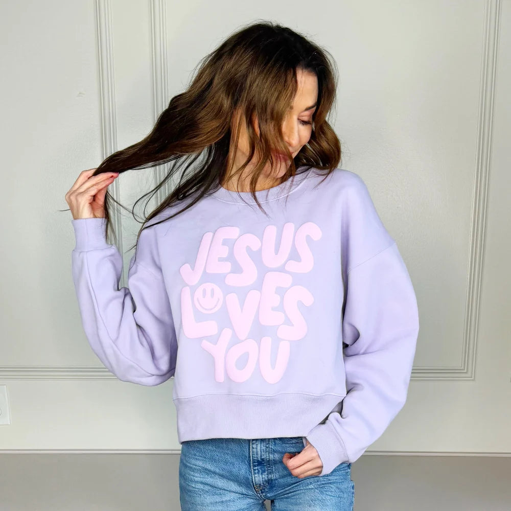 Woman wearing lilac sweatshirt that says &