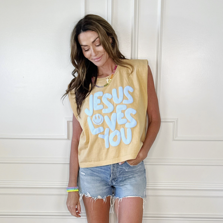 Woman wearing a yellow tank top with &