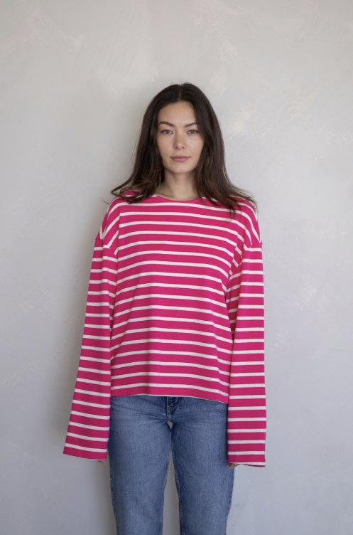 Woman wearing pink and white stripe shirt and jeans on plain background