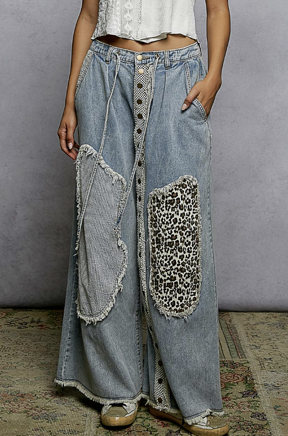 Woman wearing patchwork jeans on plain background