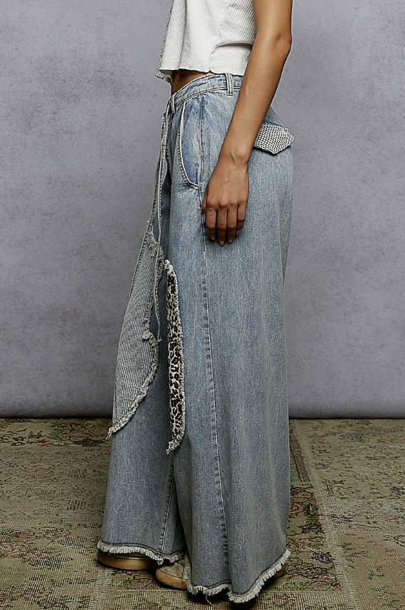 Woman wearing patchwork jeans on plain background