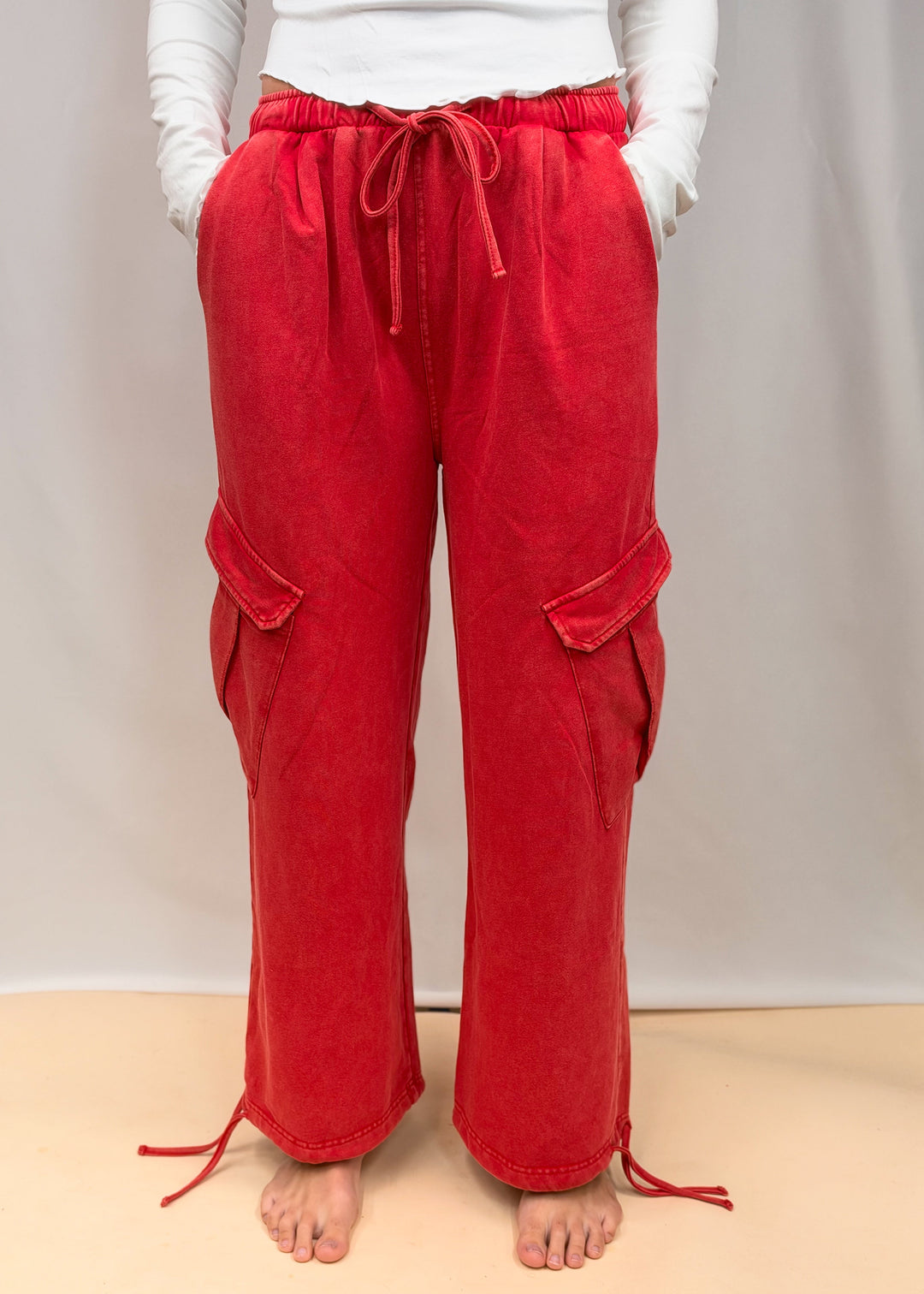 Woman wearing white top and red pants on plain background