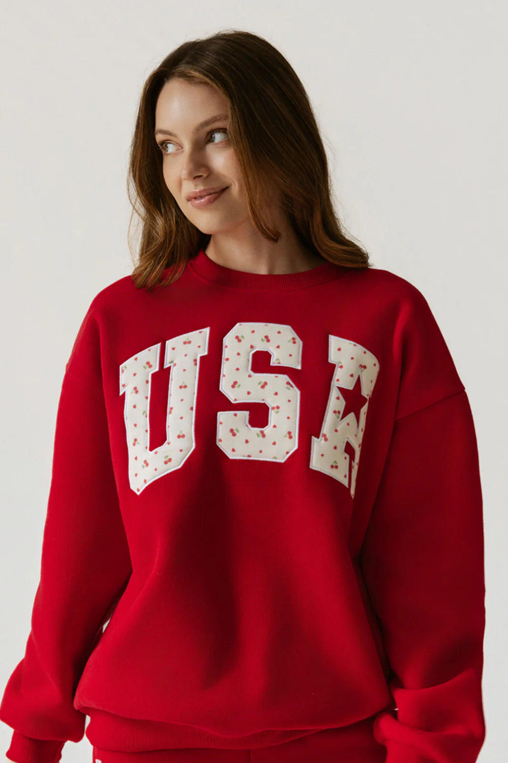 Woman wearing a red sweatshirt with &