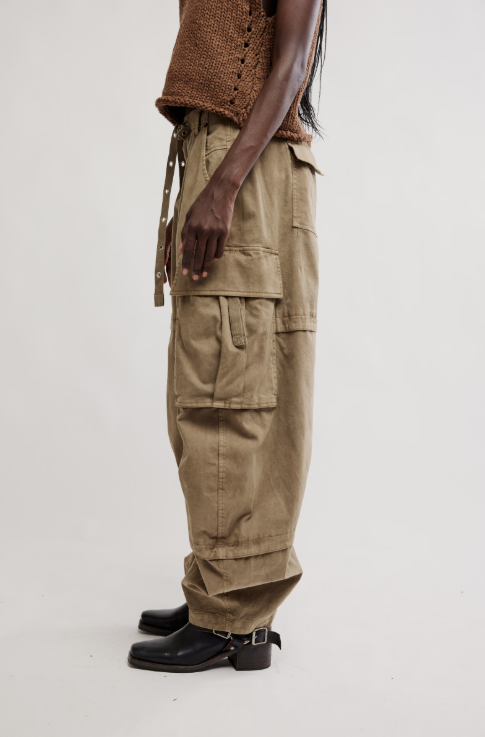 Woman shown from the side wearing khaki barrel cargo pant and brown knit tank on white background