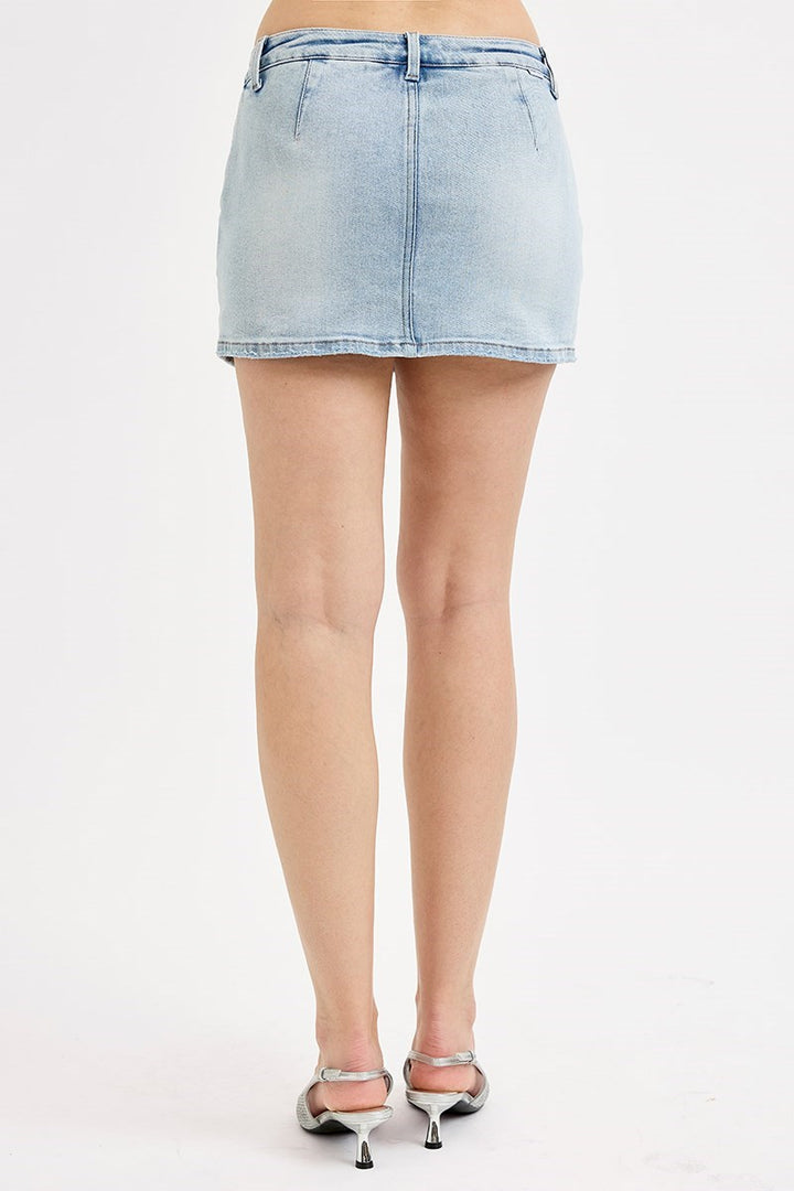Light blue denim mini skirt worn by a person on a white background