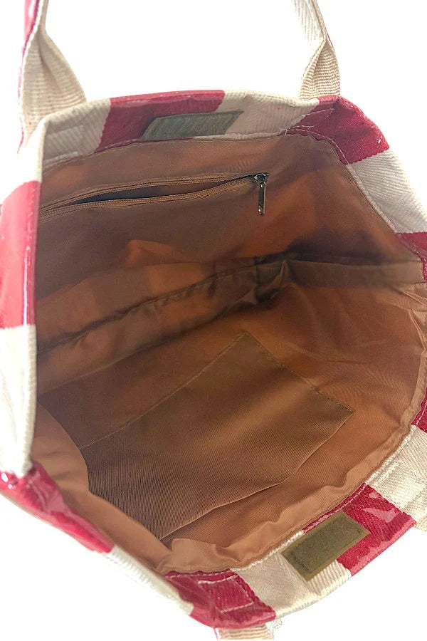 Open tote bag with red and beige patterned exterior and brown interior.