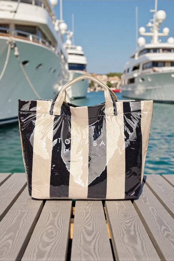 Striped tote bag on a wooden surface with yachts in the background