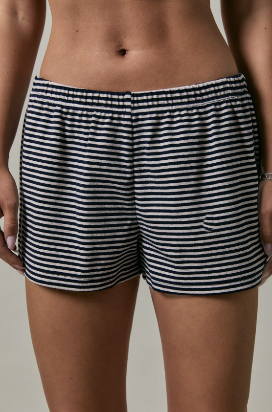 Black and white striped shorts worn by a person on a neutral background