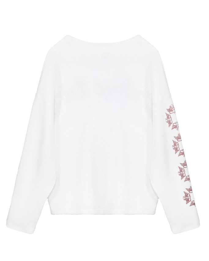 A white long-sleeve top with a dusty rose embroidered floral pattern down one sleeve, shown against a plain white background.