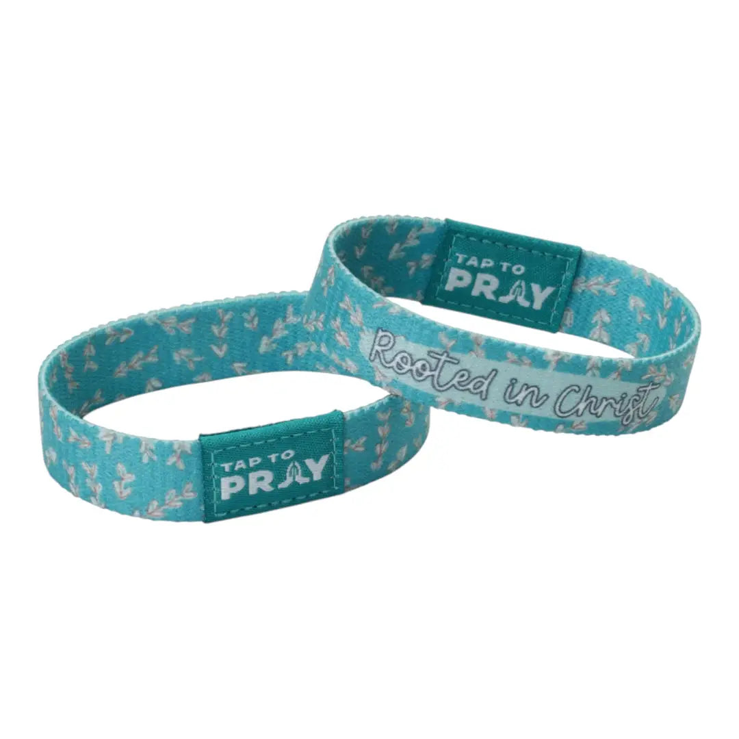 Two teal fabric wristbands with a white floral pattern, one featuring the text &