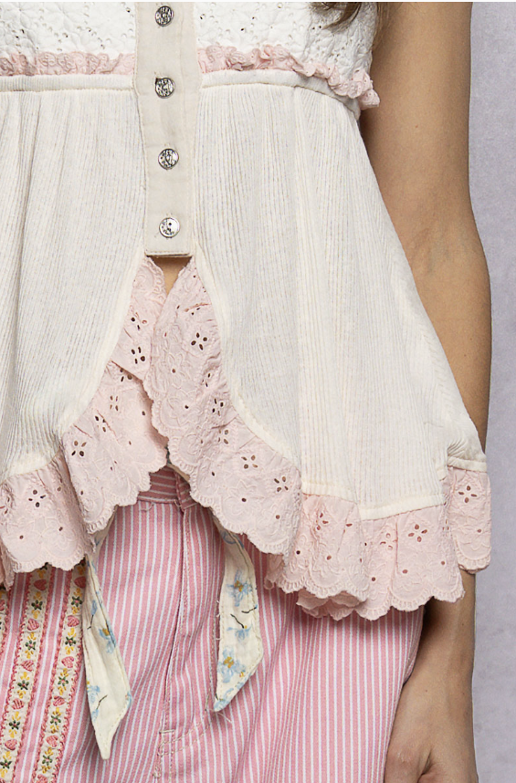 Close-up of a person wearing a white lace-trimmed dress with a pink striped skirt.