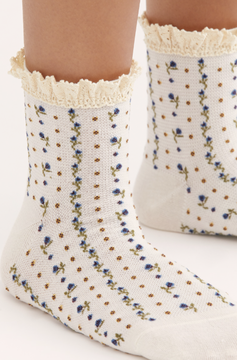 Floral patterned socks with lace trim worn by a person on a white background