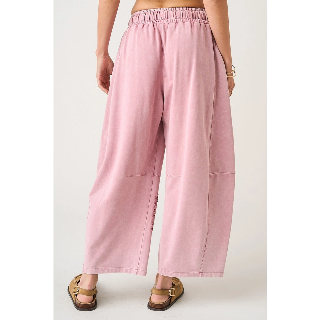 Pink wide-leg pants worn by a person on a white background