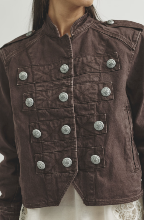 Close up of woman wearing chocolate brown band jacket on white background