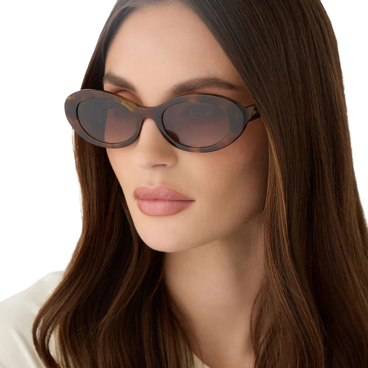 Woman wearing a pair of sunglasses with a neutral background